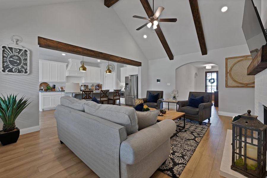 Living area featuring high vaulted ceiling, recessed lighting, arched walkways, light wood-type flooring, and beam ceiling Living area featuring high vaulted ceiling, recessed lighting, arched walkways, light wood-type flooring, and beam ceiling