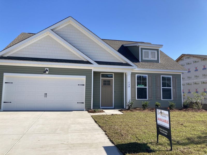 View of front of home with roof with shingles, concrete driveway, a front lawn, and an attached garage
