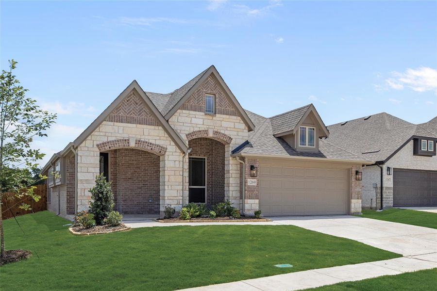 Single-story home with brick and stone exterior, arched entry, two-car garage, and green front lawn Single-story home with brick and stone exterior, arched entry, two-car garage, and green front lawn