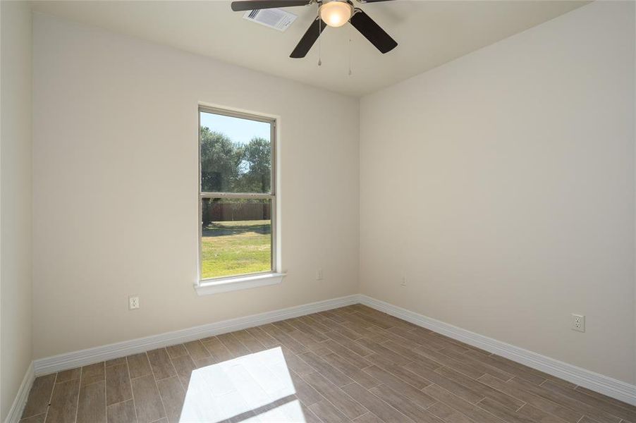 Spare room featuring light hardwood / wood-style flooring, a healthy amount of sunlight, and ceiling fan