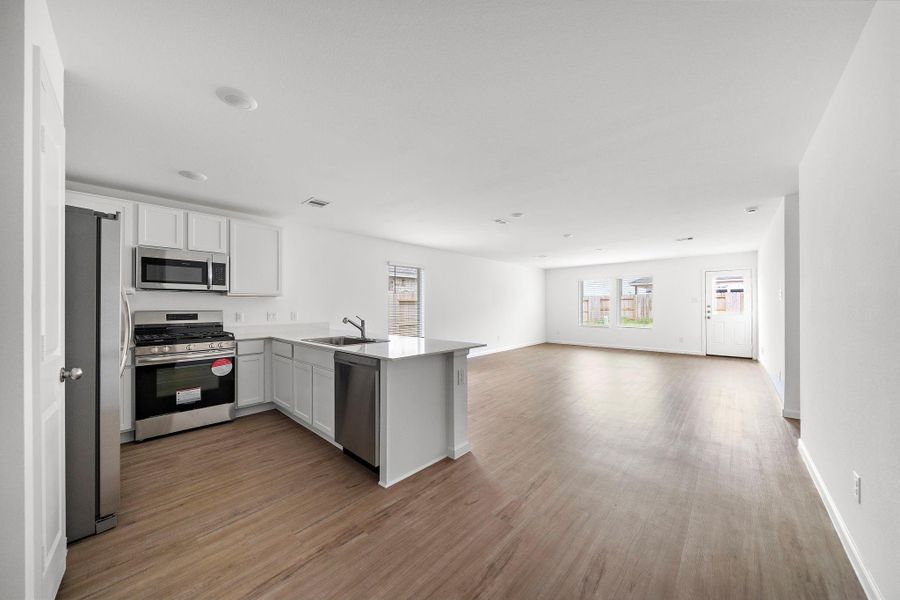 Kitchen open to living area with plenty of natural light.