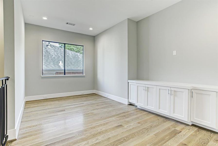 Large upstairs gameroom with built-in cabinets. The custom 5" white oak flooring is throughout the house.