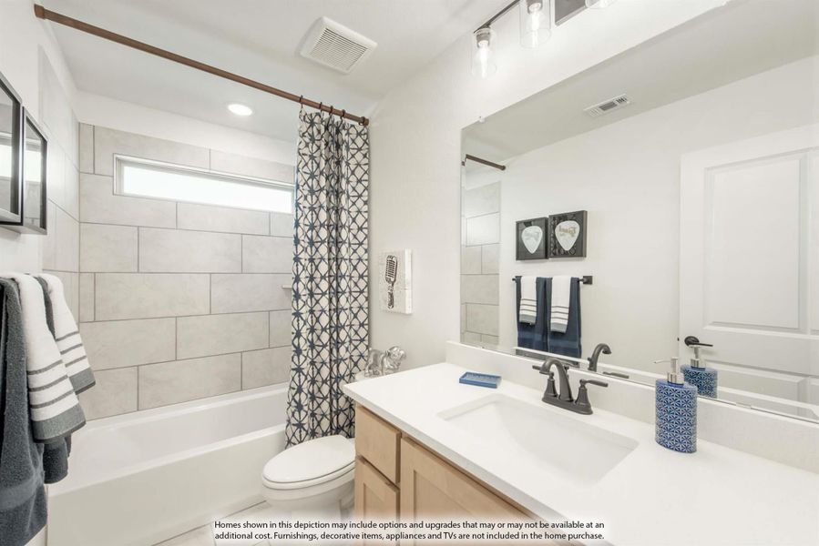 Bathroom with tiled tub-shower combo, white countertop vanity, and large mirror