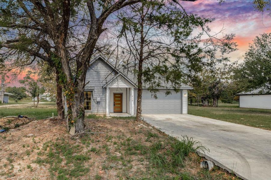 View of front facade with driveway and an attached garage View of front facade with driveway and an attached garage