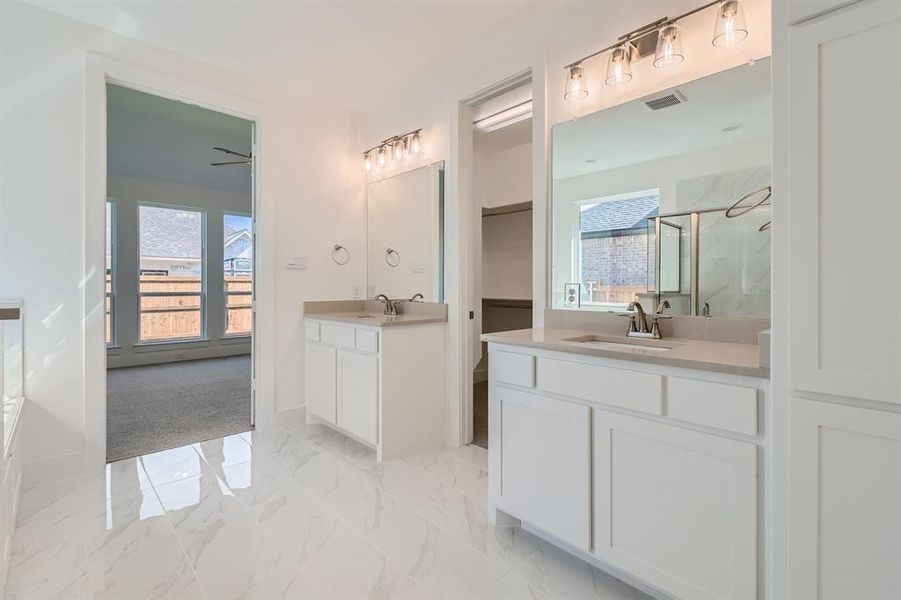 Bathroom featuring a shower with door, a healthy amount of sunlight, vanity, and ceiling fan