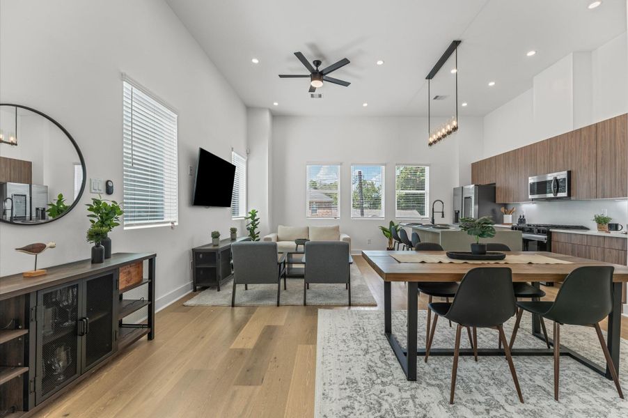 The second floor boasts a spacious open-concept living, dining, and kitchen area filled with natural light from abundant windows, featuring sleek modern finishes and warm engineered hardwood floors that create the perfect blend of style and comfort for everyday living and entertaining.
