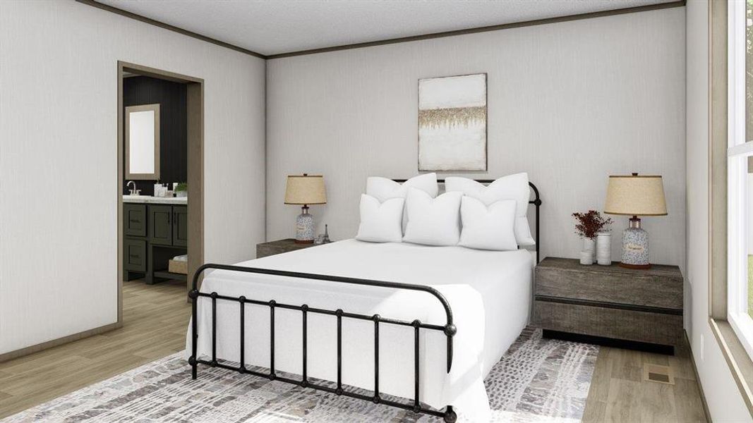 Bedroom with ensuite bath, a textured ceiling, and light wood-type flooring