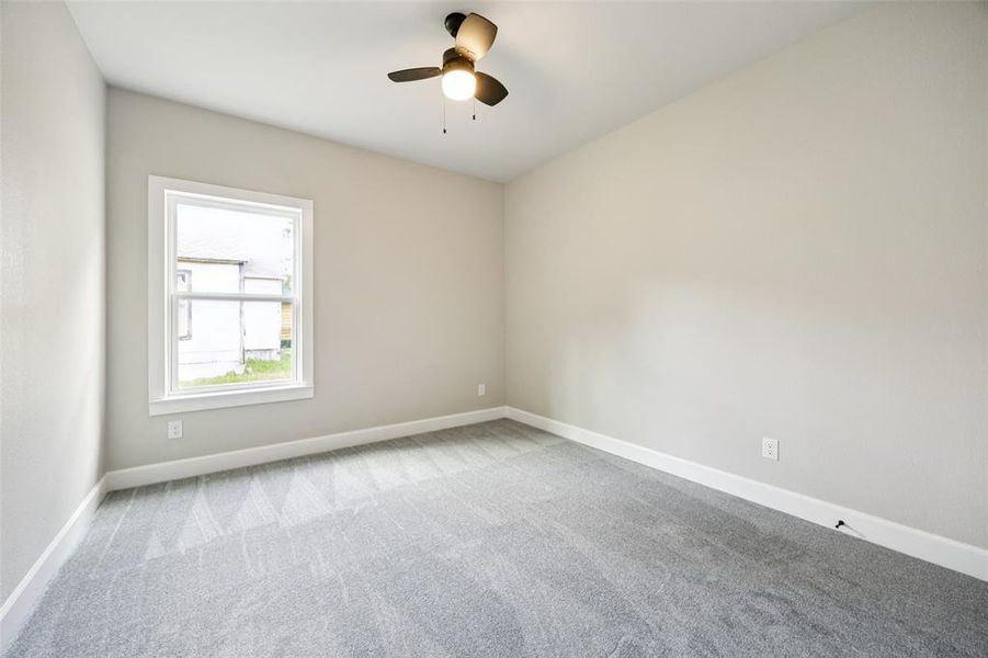 Carpeted empty room with baseboards and ceiling fan Carpeted empty room with baseboards and ceiling fan