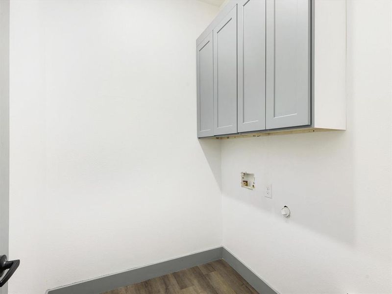 Laundry area featuring dark wood-style flooring, cabinet space, hookup for a gas dryer, and hookup for a washing machine Laundry area featuring dark wood-style flooring, cabinet space, hookup for a gas dryer, and hookup for a washing machine