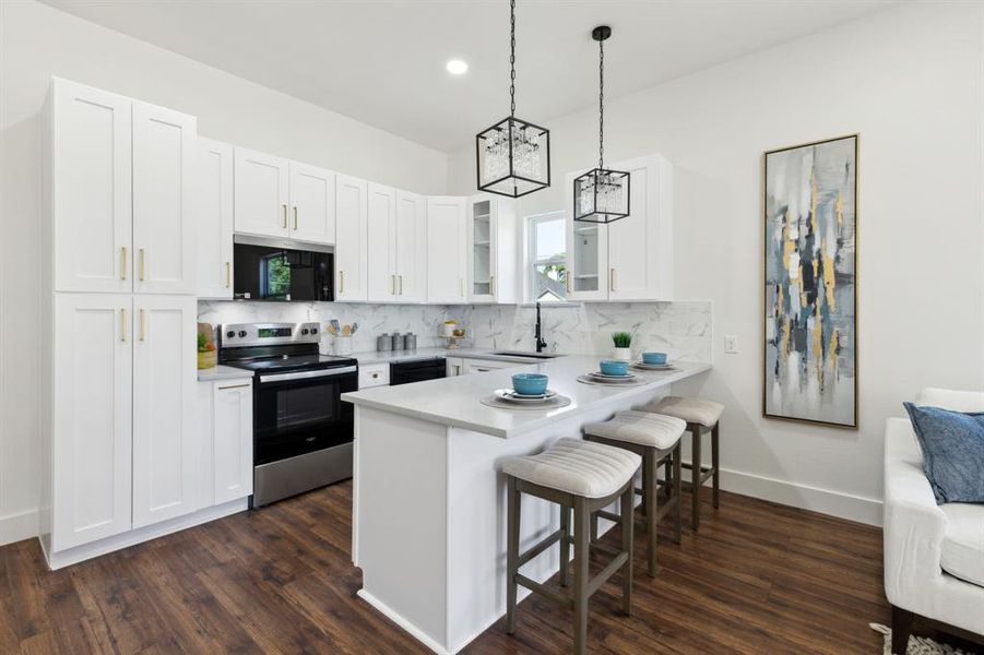 Kitchen with glass insert cabinets, stainless steel range with electric stovetop, a kitchen bar, a peninsula, and backsplash Kitchen with glass insert cabinets, stainless steel range with electric stovetop, a kitchen bar, a peninsula, and backsplash