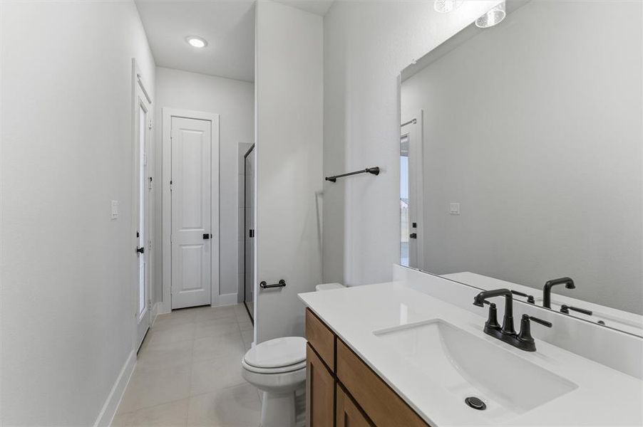 Full bathroom featuring a stall shower, vanity, and light tile patterned floors Full bathroom featuring a stall shower, vanity, and light tile patterned floors
