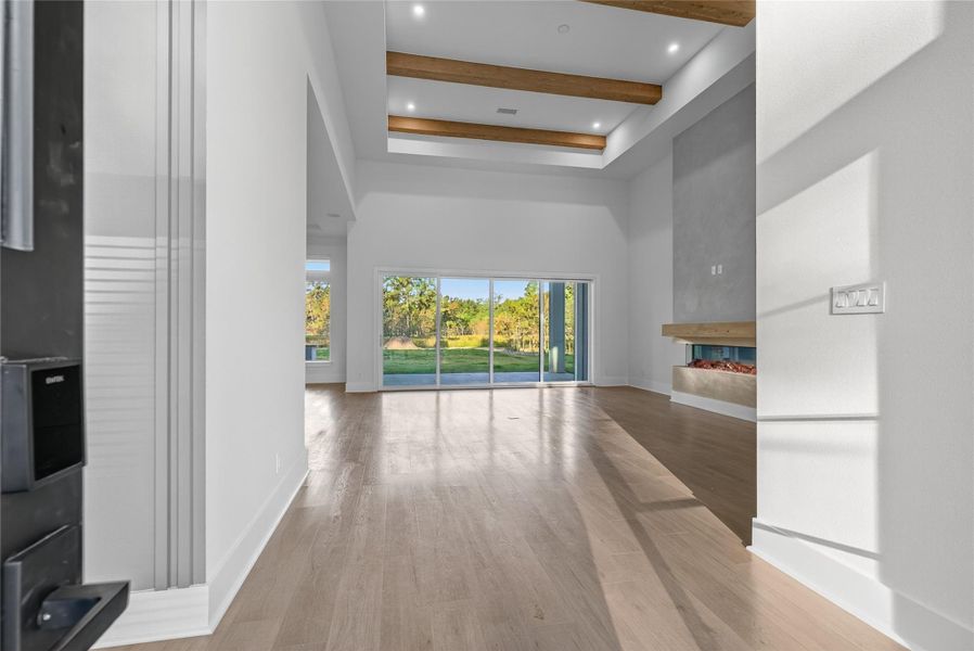 Light-filled interior features tall windows, warm wood-look flooring, and a bright, neutral color palette. **Images are from a previously completed project. **