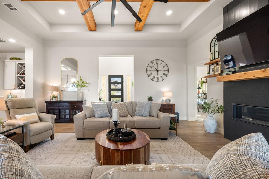 Living room with a towering ceiling, a fireplace, and light wood-type flooring Living room with a towering ceiling, a fireplace, and light wood-type flooring