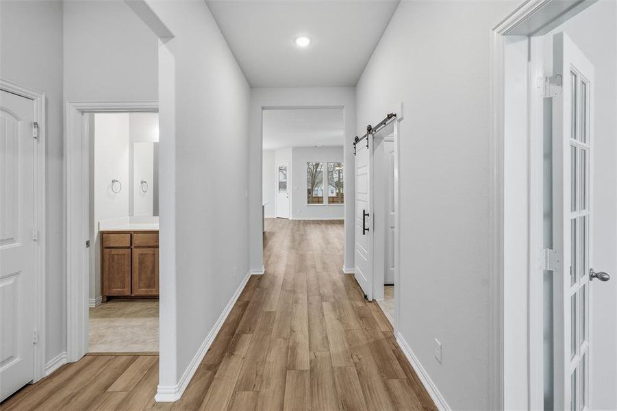 Corridor with a barn door and light wood-style floors Corridor with a barn door and light wood-style floors