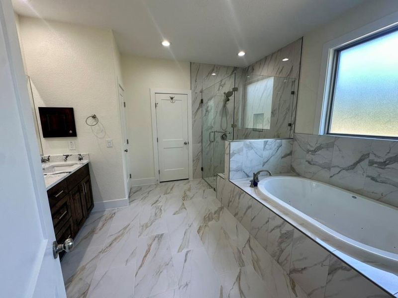 Full bathroom featuring a bath, a marble finish shower, vanity, recessed lighting, and light marble finish floors
