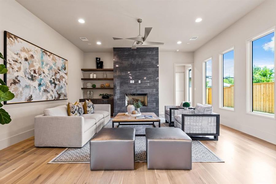 Living area featuring wood finished floors, ceiling fan, a fireplace, and recessed lighting Living area featuring wood finished floors, ceiling fan, a fireplace, and recessed lighting