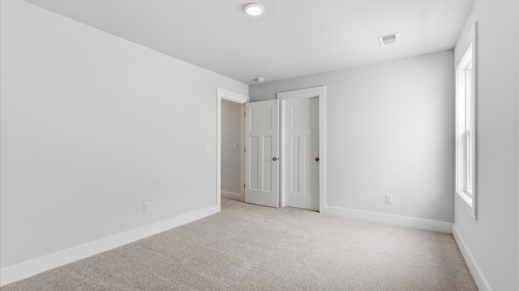 Refined bedroom design with large windows for daylight-filled mornings and peaceful views at Foxbank in Gray Court, SC