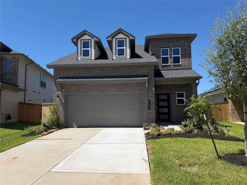 Front exterior of a new home in La Segarra, Brookshire, TX, highlighting curb appeal (Image 2). Front exterior of a new home in La Segarra, Brookshire, TX, highlighting curb appeal (Image 2).