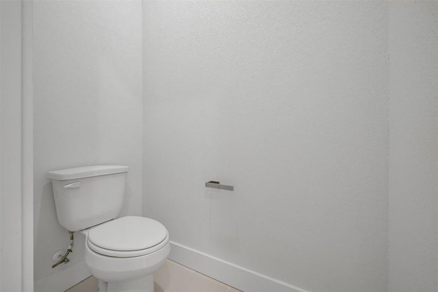 Bathroom with tile patterned floors and baseboards