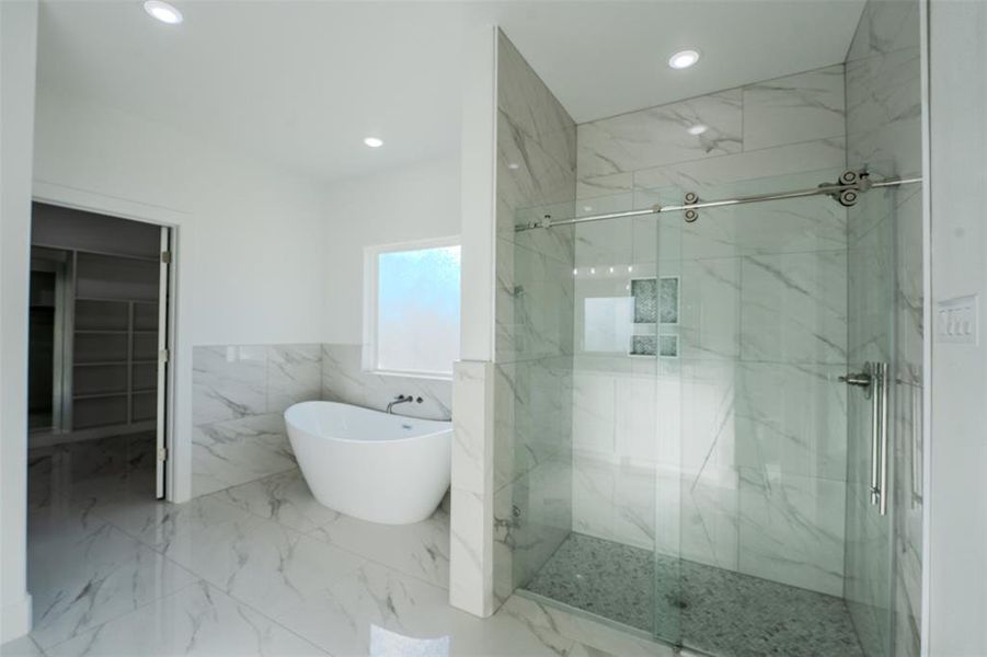 Bathroom with a freestanding bath, a marble finish shower, tile walls, marble tiled flooring, and a spacious closet Bathroom with a freestanding bath, a marble finish shower, tile walls, marble tiled flooring, and a spacious closet
