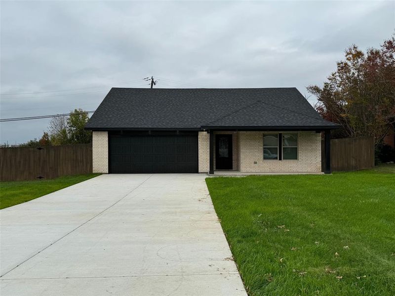 View of front facade with a front lawn and a garage