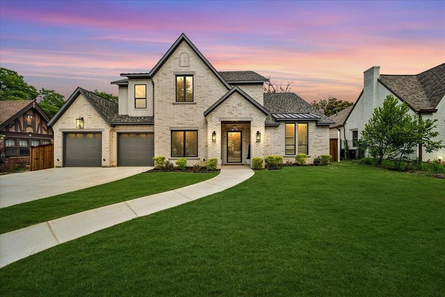 View of front of house featuring a garage and a lawn