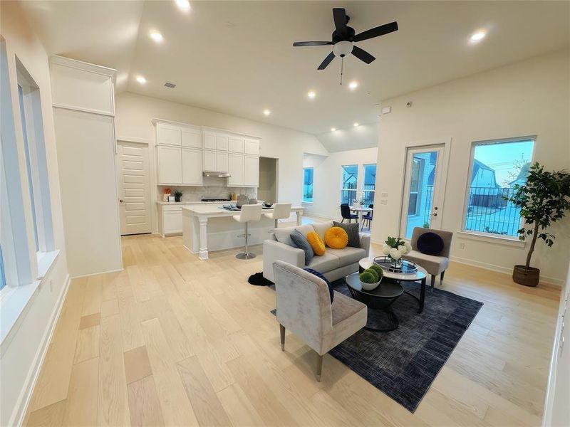 Living room featuring light hardwood / wood-style floors, ceiling fan, and lofted ceiling