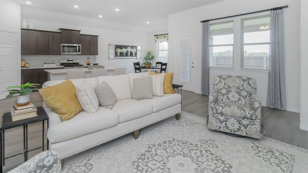 Living area featuring dark wood-finish flooring and multiple windows