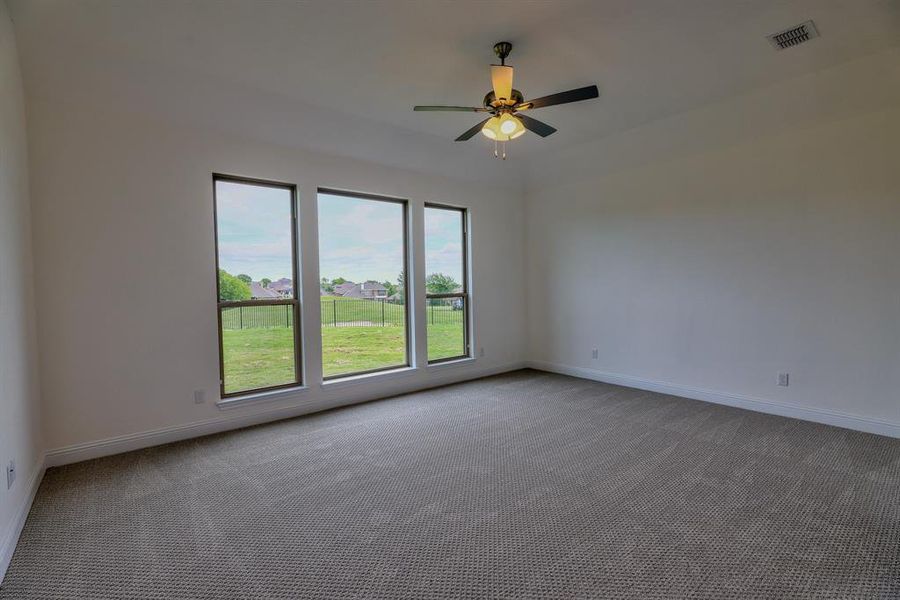 Carpeted spare room with baseboards and a ceiling fan