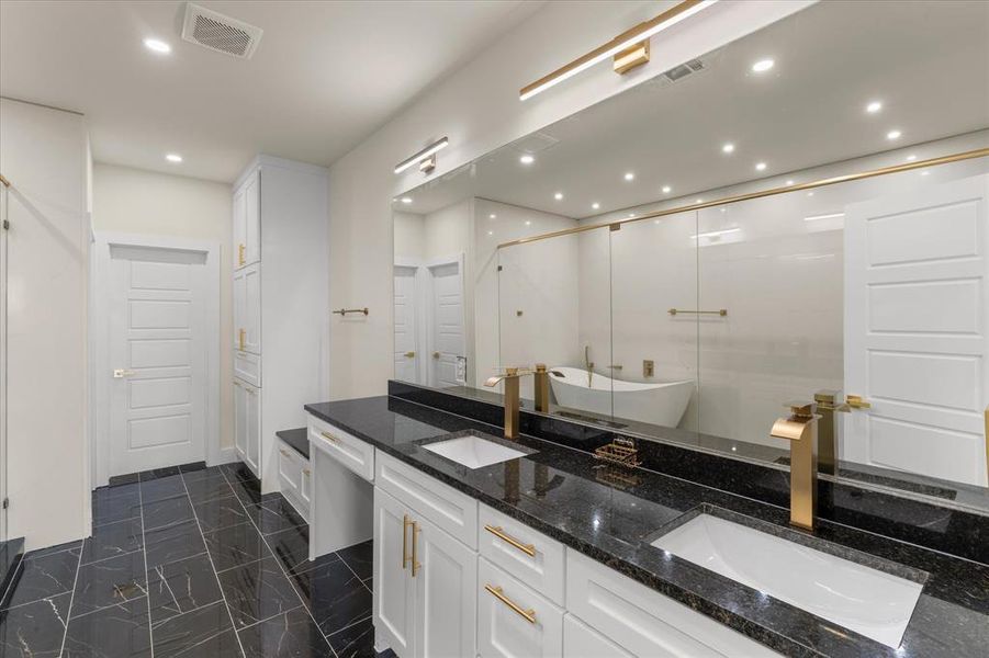 Bathroom featuring double vanity, a freestanding bath, recessed lighting, and a stall shower