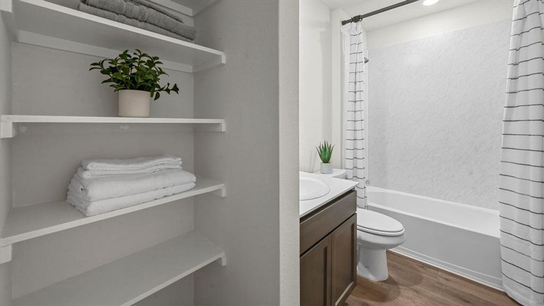 Bathroom featuring vanity, dark wood-style floors, and shower / bath combination with curtain Bathroom featuring vanity, dark wood-style floors, and shower / bath combination with curtain