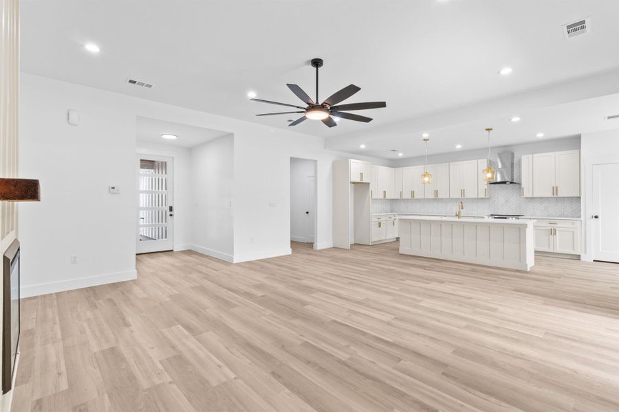 Unfurnished living room with recessed lighting, light wood finished floors, a ceiling fan, and a fireplace