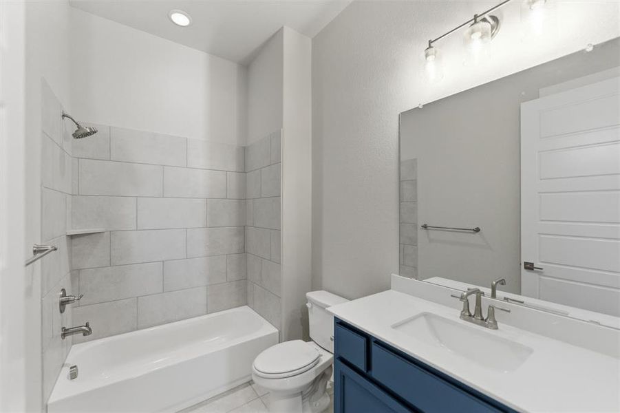 Bathroom featuring vanity, washtub / shower combination, and light tile patterned flooring