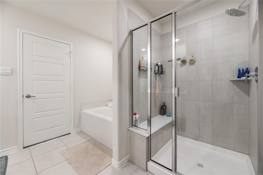 Full bathroom with a bath, a shower stall, and light tile patterned floors