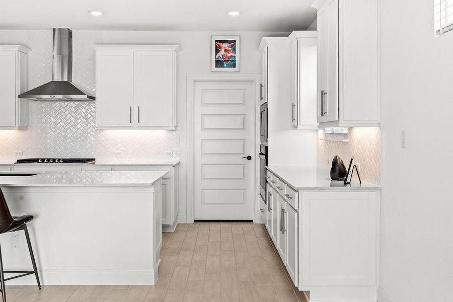 Light quartz countertops glisten in the soft sunlight of this room.