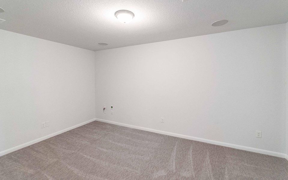 Carpeted spare room with baseboards and a textured ceiling