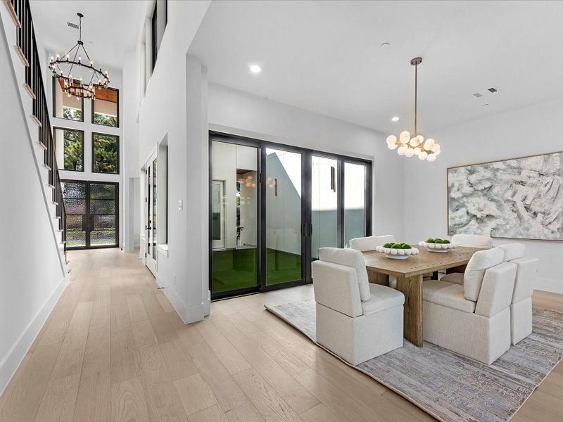The dining room features sliding doors that open seamlessly to your private courtyard, creating the perfect setting for effortless indoor-outdoor entertaining.
