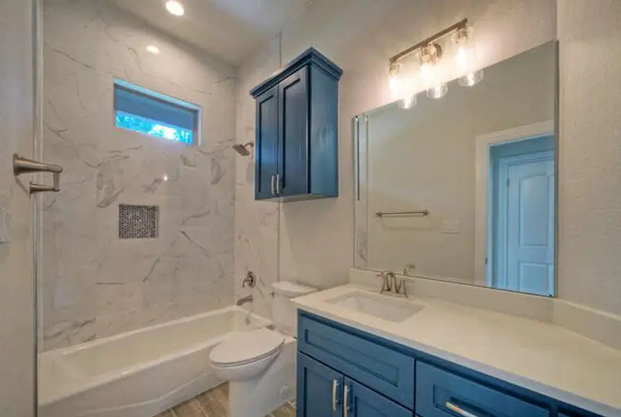 Bathroom featuring vanity, bathtub / shower combination, and wood finished floors