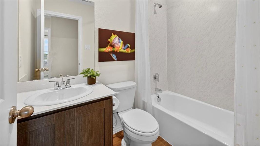 Bathroom featuring a white vanity with an undermount sink, brushed nickel faucet, and a wall-mounted mirror Bathroom featuring a white vanity with an undermount sink, brushed nickel faucet, and a wall-mounted mirror