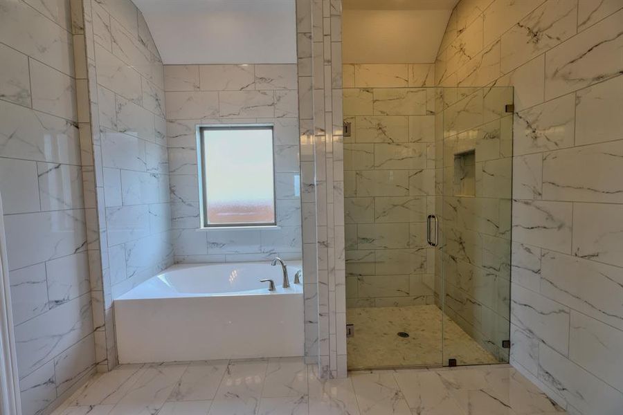 Bathroom with a garden tub, a shower stall, and marble finish floors