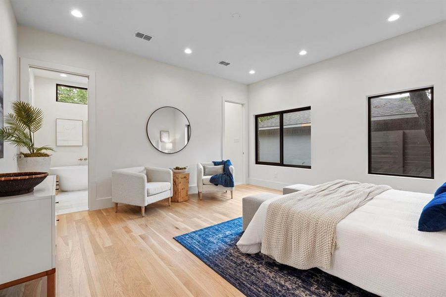 Bedroom featuring light wood finished floors, recessed lighting, and ensuite bath Bedroom featuring light wood finished floors, recessed lighting, and ensuite bath