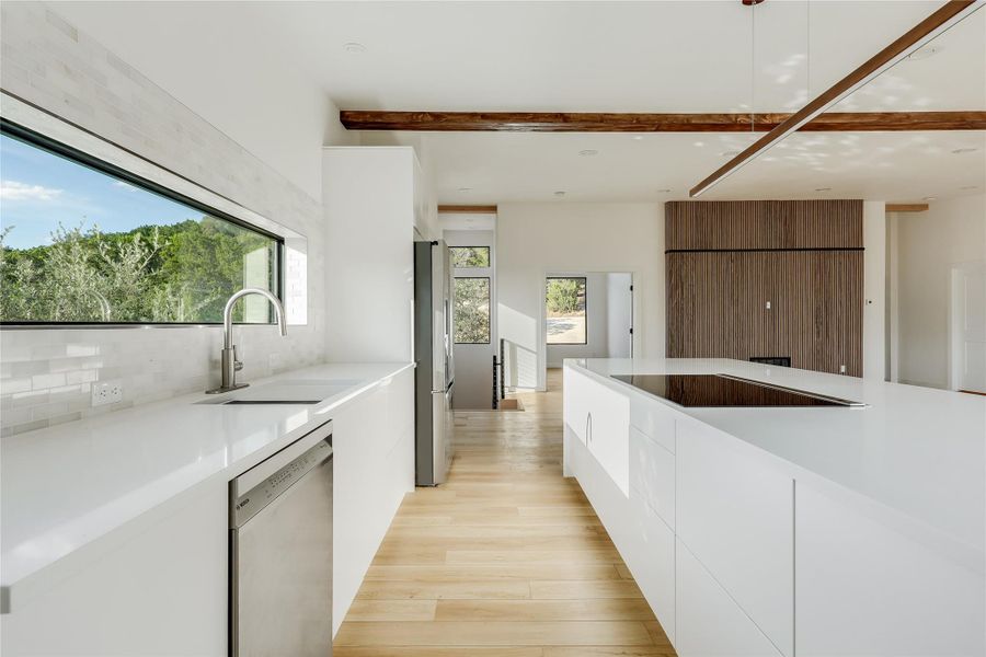 Kitchen with modern cabinets, white cabinets, appliances with stainless steel finishes, tasteful backsplash, and light wood-style floors Kitchen with modern cabinets, white cabinets, appliances with stainless steel finishes, tasteful backsplash, and light wood-style floors