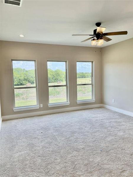 Spare room featuring a ceiling fan and light colored carpet
