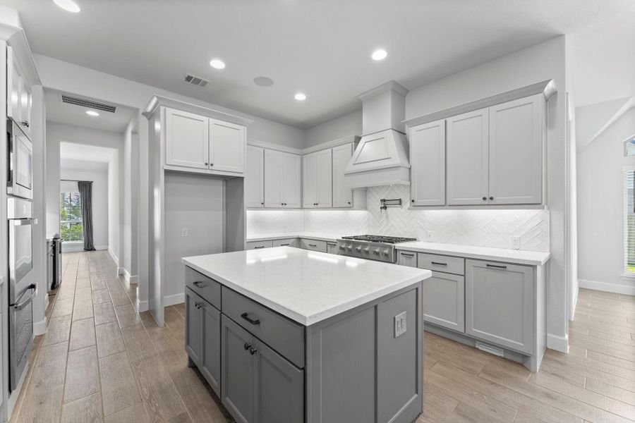 The chef’s kitchen is a true showpiece with GE Café appliances, quartz countertops, double ovens, pot filler, butler’s pantry, soft close drawers, spice racks, and under cabinet lighting. The chef’s kitchen is a true showpiece with GE Café appliances, quartz countertops, double ovens, pot filler, butler’s pantry, soft close drawers, spice racks, and under cabinet lighting.