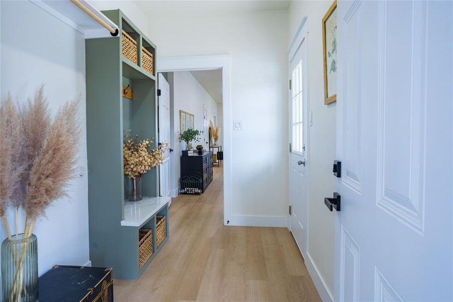 Mudroom with light wood-type flooring and baseboards