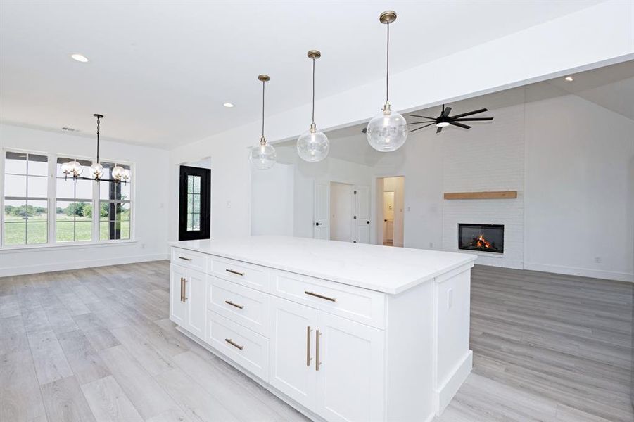Kitchen with recessed lighting, a ceiling fan, a center island, open floor plan, and a fireplace