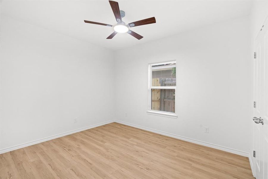 Empty room featuring light wood-style flooring and a ceiling fan Empty room featuring light wood-style flooring and a ceiling fan