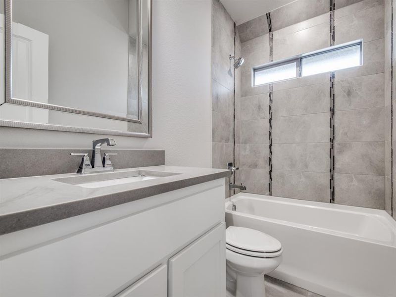 Bathroom with toilet, vanity, and washtub / shower combination Bathroom with toilet, vanity, and washtub / shower combination