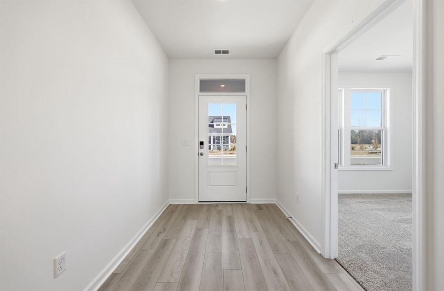 Doorway with wood finished floors and healthy amount of natural light