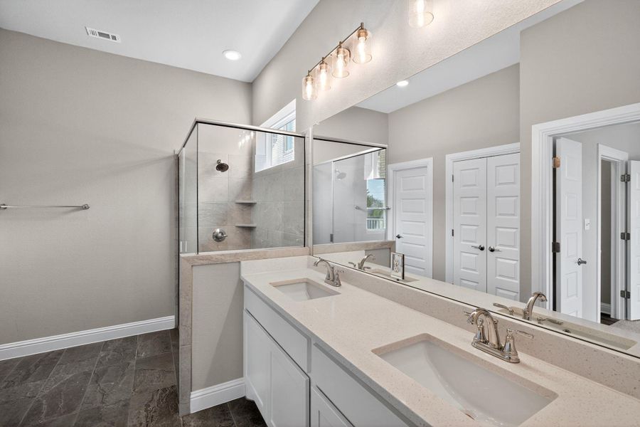 Bathroom with a stall shower, double vanity, and recessed lighting Bathroom with a stall shower, double vanity, and recessed lighting